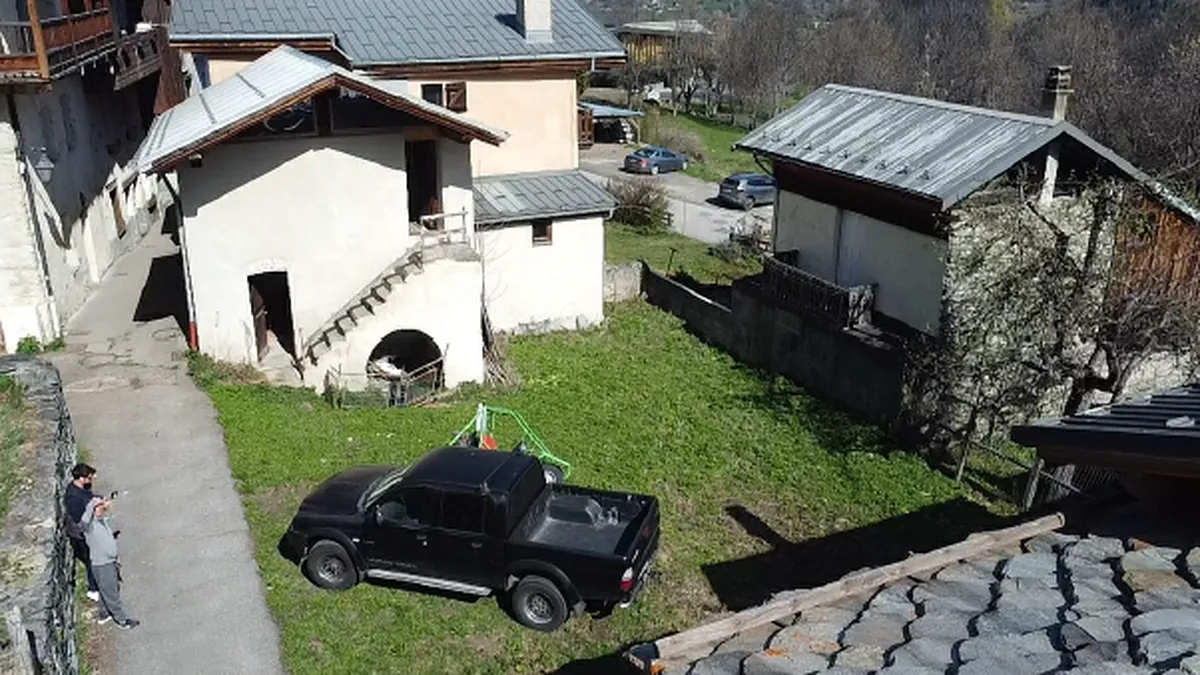 Drone view of a village plot in Savoie with an old house and bare garden, before works